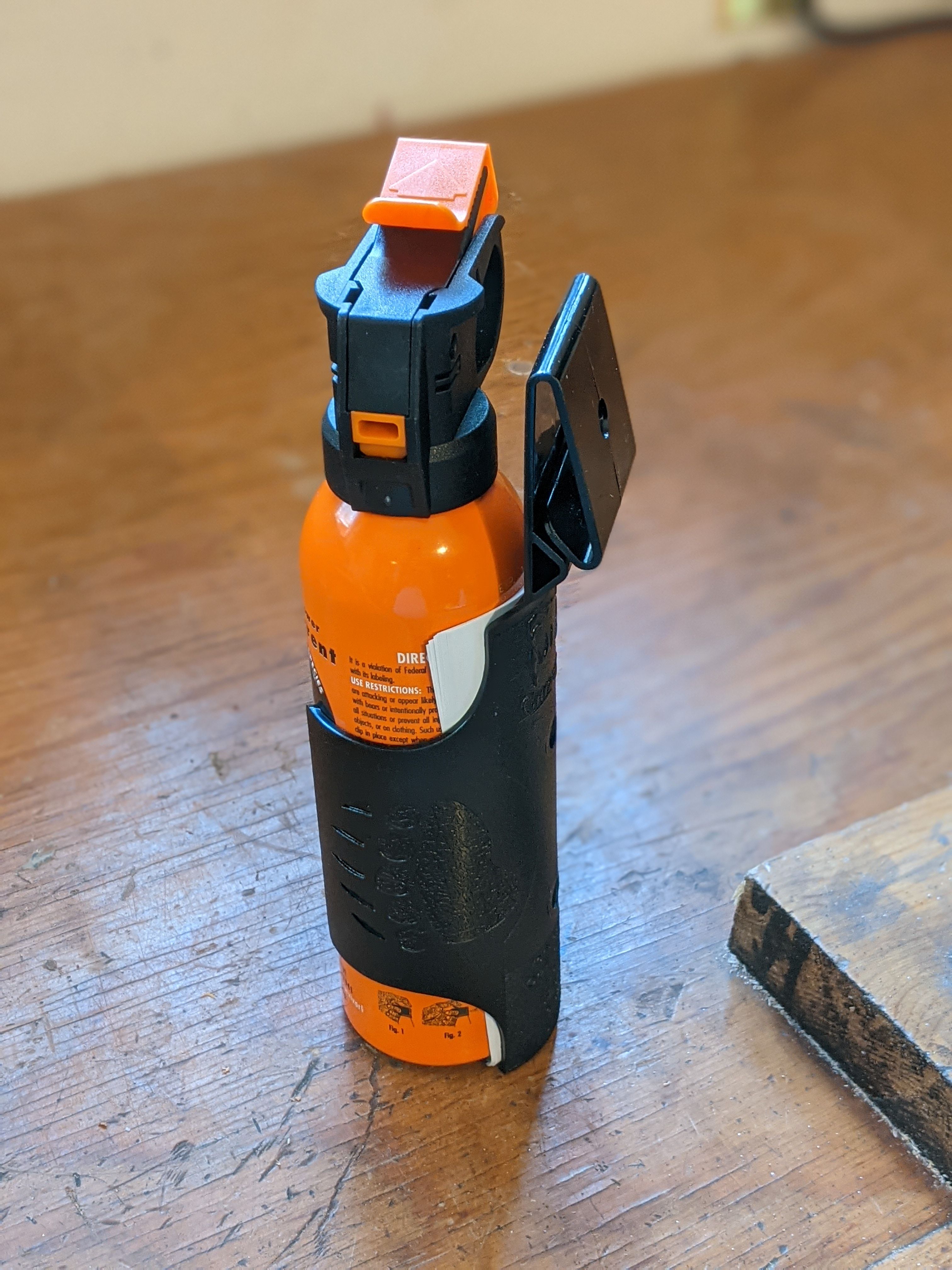 Bear spray with belt attachment